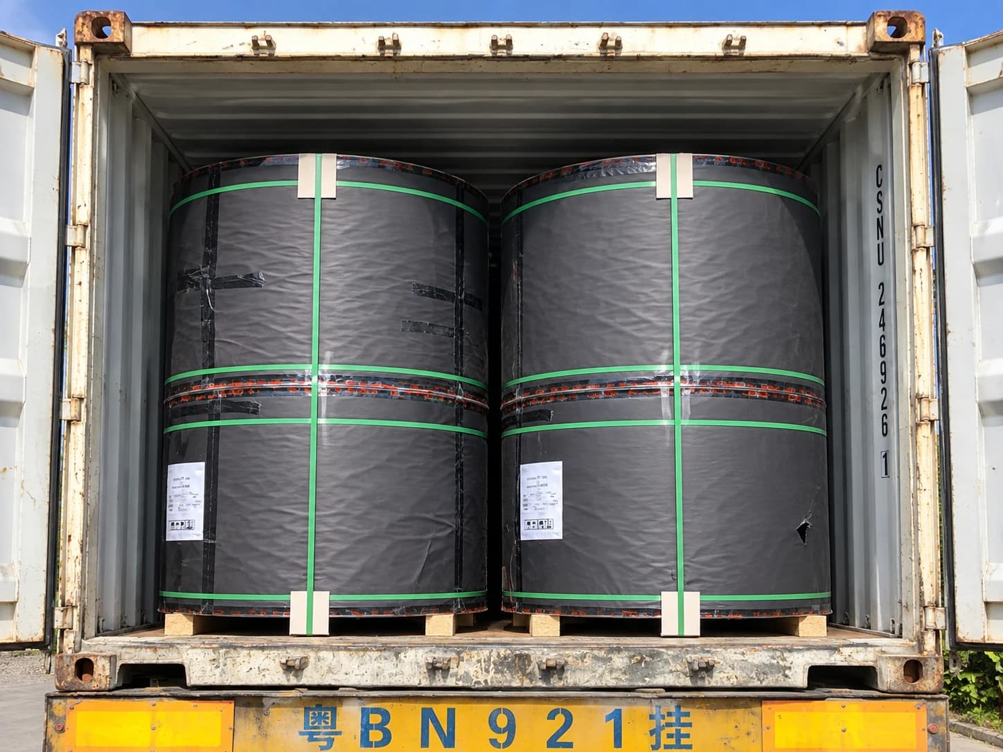 Wrapped black paper reels loaded in an export container
