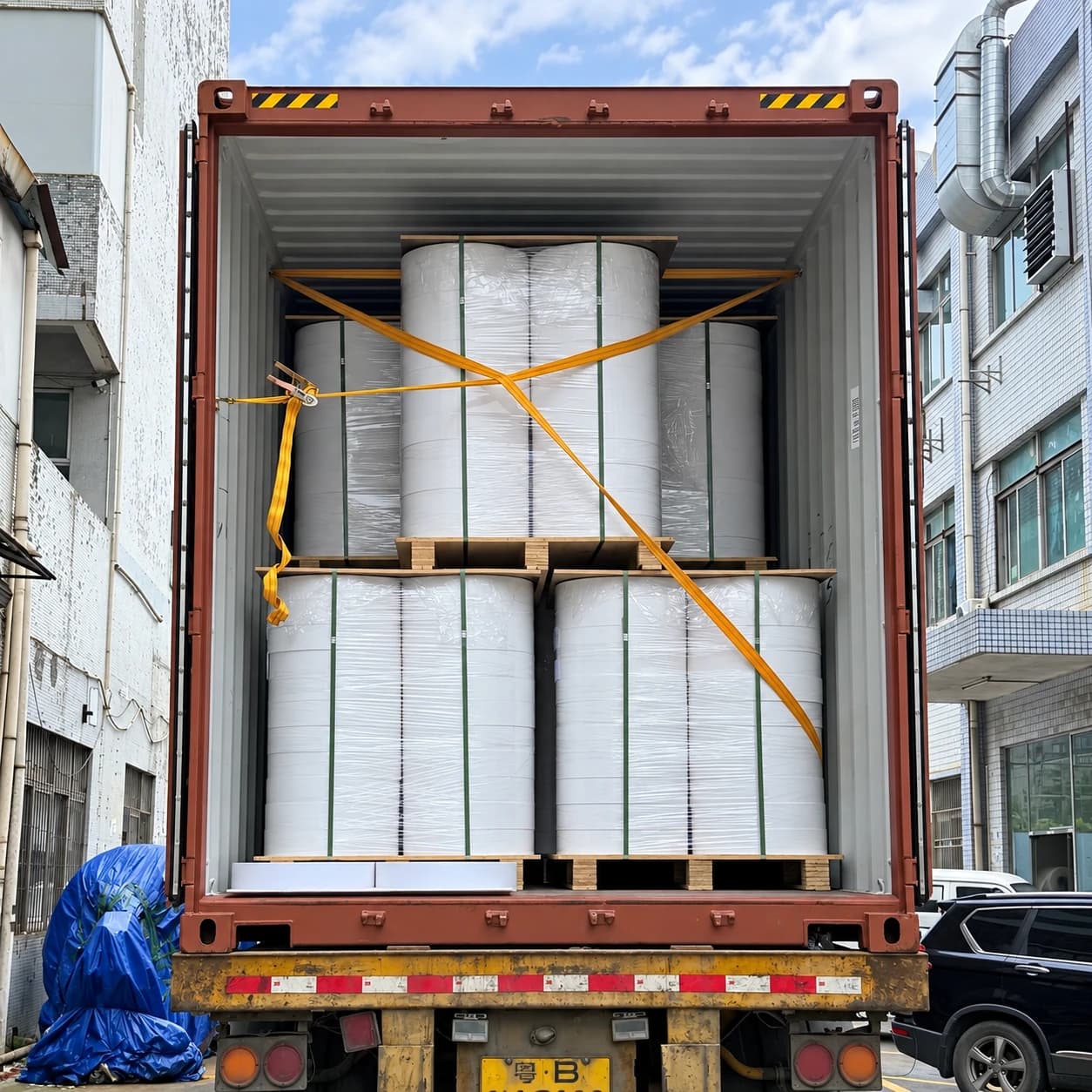 Strapped wrapped white paper reels in an export container