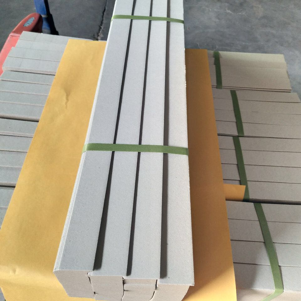 Grooved grey board components bundled for rigid box converting